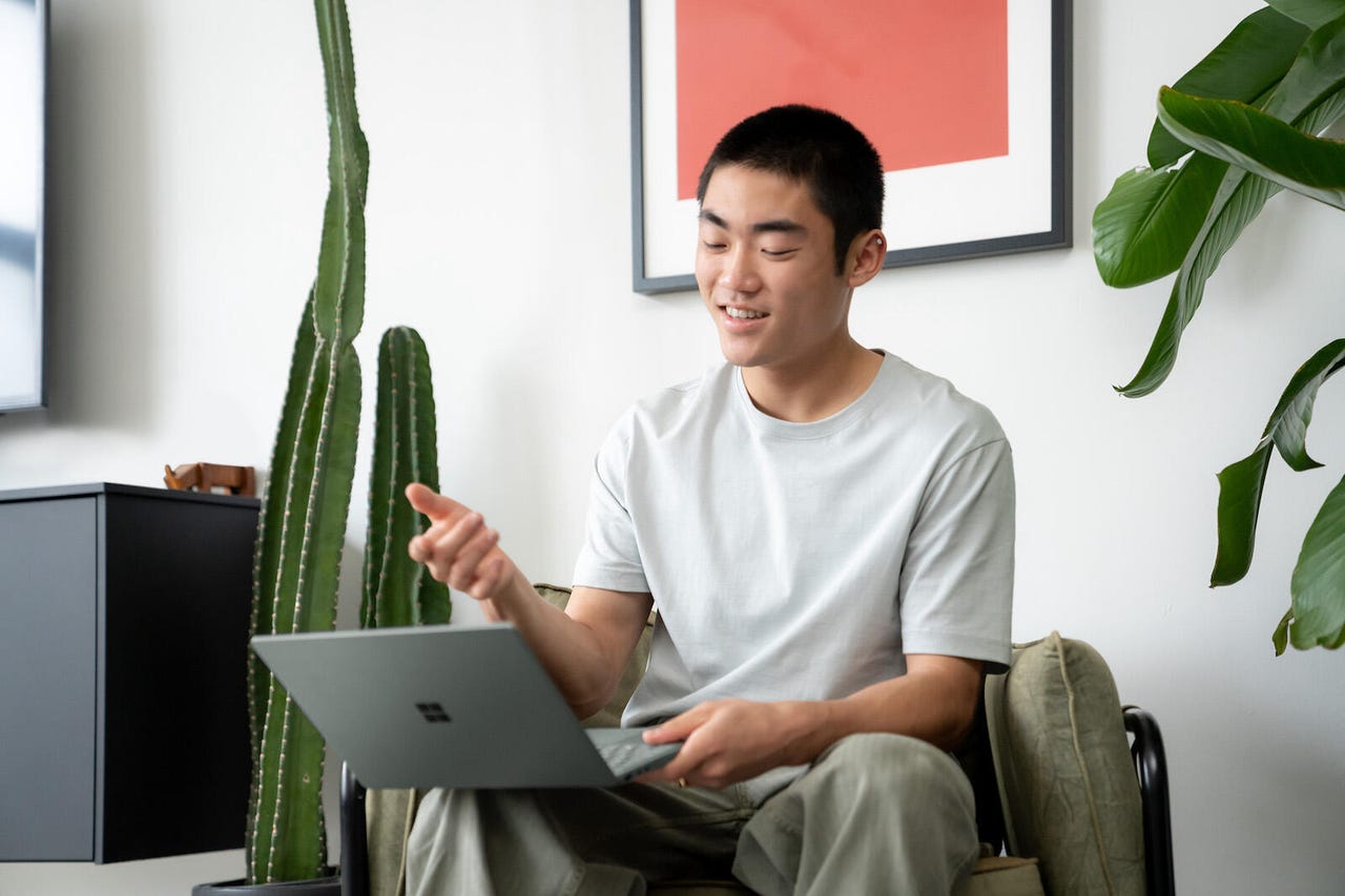 Hombre sentado usando una computadora portátil Microsoft Surface