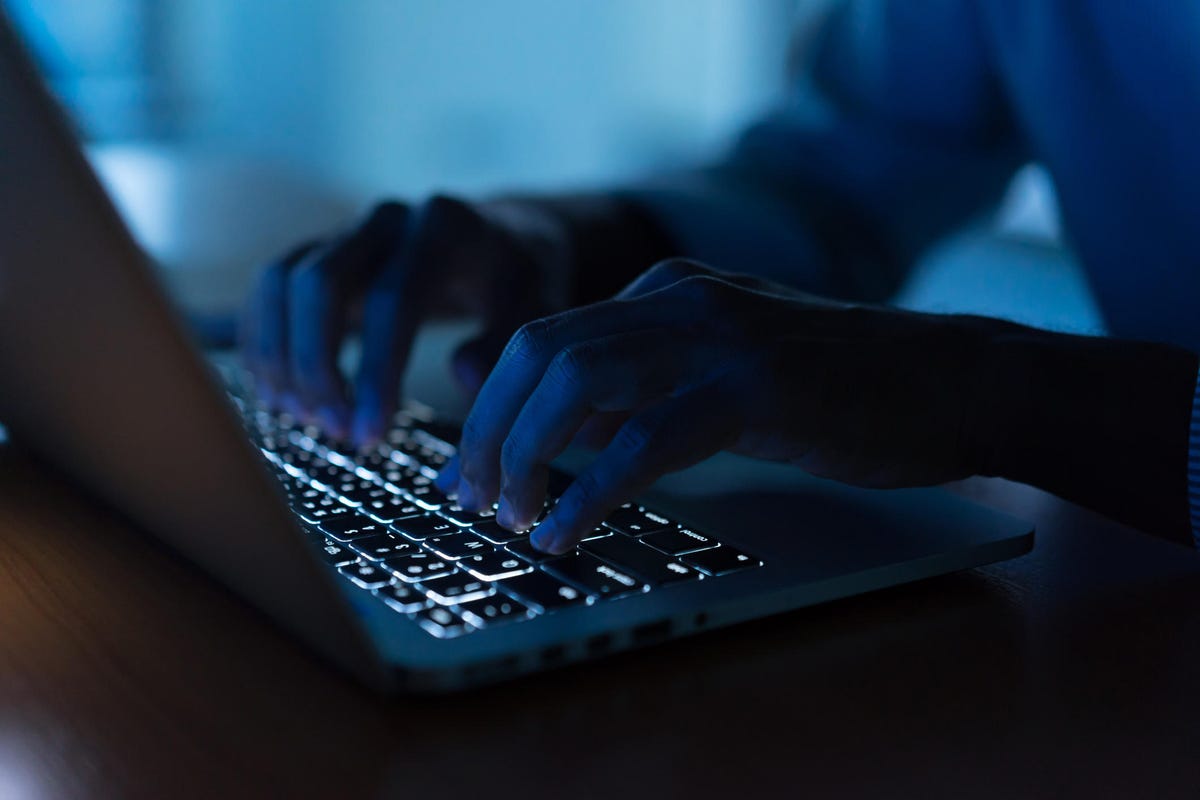 مرد برنامه نویس نزدیک در حال تایپ روی لپ تاپ صفحه کلید برای ثبت سیستم داده یا دسترسی به رمز عبور در اتاق عملیات تاریک، مفهوم امنیت سایبری