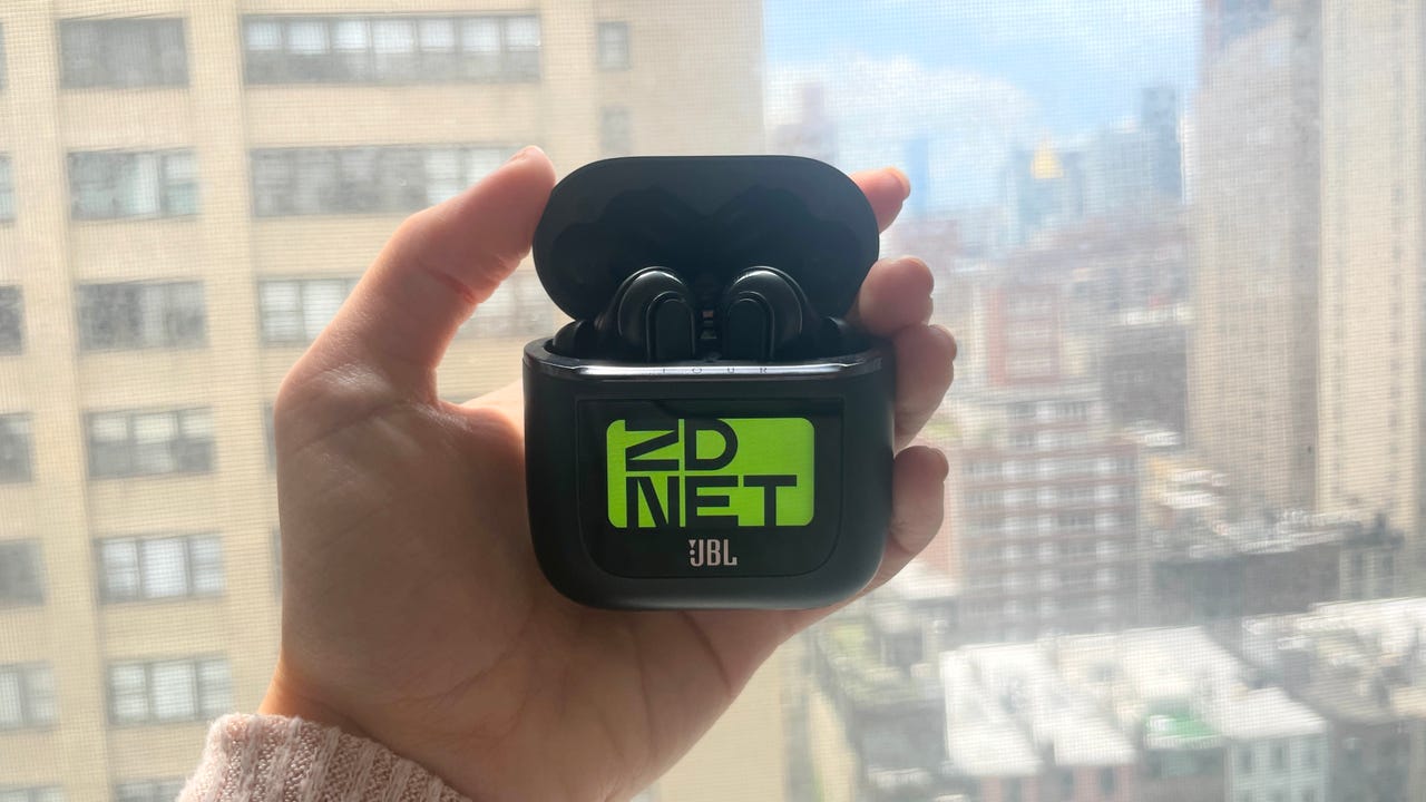 JBL Tour Pro 2 earbuds in case with ZDNET logo against window