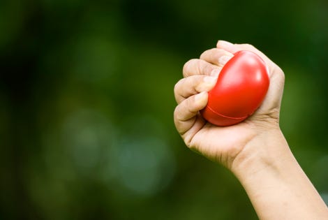 Hand squeezing a red stressball
