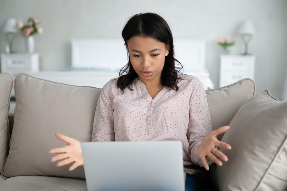 Woman having problems with computer looks at screen feels annoyed