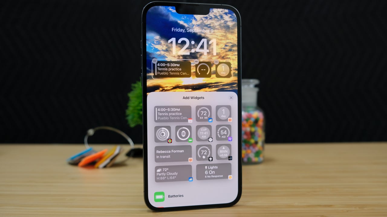 iOS 16 widgets on lock screen of standing iPhone