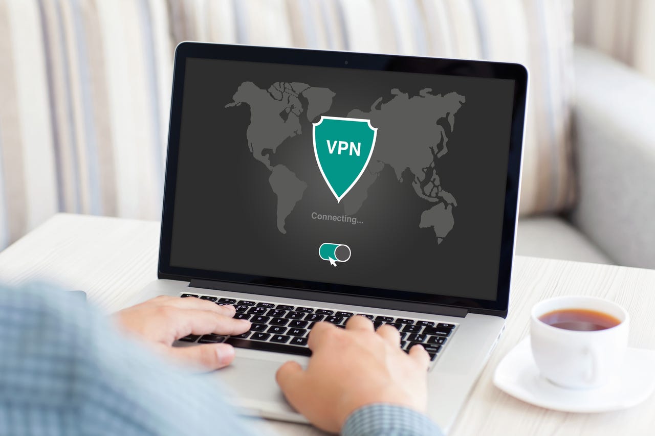 Person typing on a laptop with a VPN logo onscreen