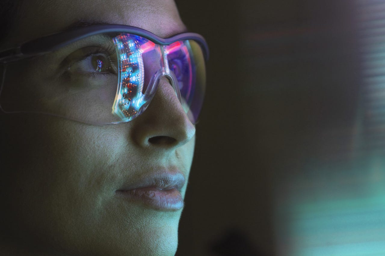 woman wearing computer glasses staring at glowing screen