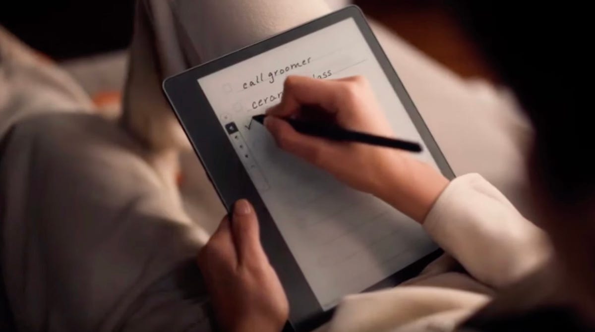 Person writing on Kindle Scribe