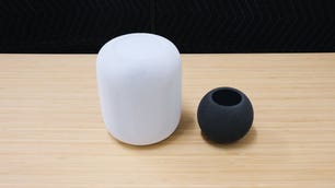 A HomePod and a HomePod Mini sitting on a desk.