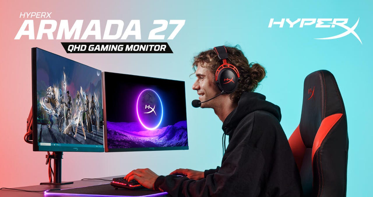 A young man is sitting at a desk, using two Armada 27 monitors to play video games on his PC.