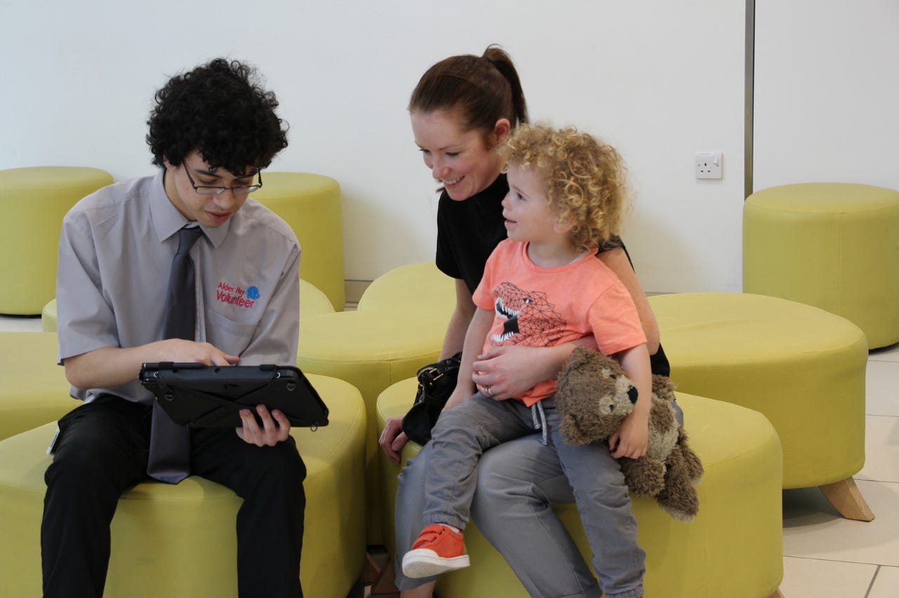 alder-hey-childrens-hospital-volunteer-gathers-feedback-from-a-family-about-their-experiences-at-the-hospital.png